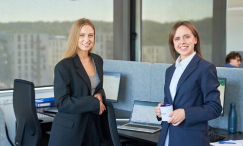 Two women, working at Baltic Assist dressed in business attire, engaged in discussion about How Danish companies can benefit from outsourcing bookkeeping in 2025