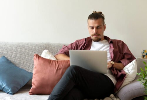 Remote worker on couch in home with pillows