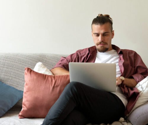 Remote worker on couch in home with pillows